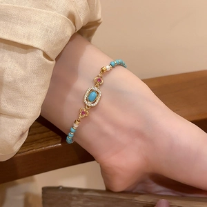 Detail of vintage beaded bracelet with turquoise stone, pearls, and gold floral accents