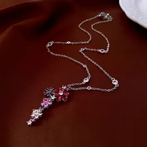Silver flower tassel pendant necklace with colorful zircon stones on silk background