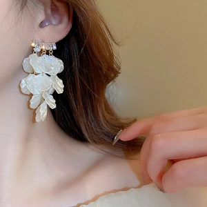 Boucles d'oreilles pendantes fleurs avec pétales blancs et incrustations de zircons