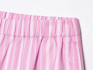 Detail view of pink and white striped shorts featuring an elastic waistband and woven texture