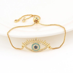 Close-up of golden evil eye bracelet with colorful zircons and adjustable slider clasp