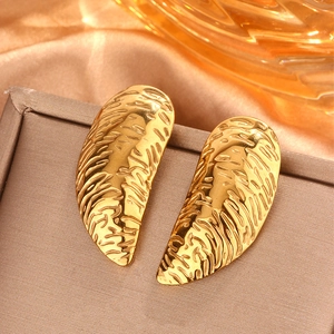 Vista macro di orecchini a cuore in oro 18K con texture in metallo martellato unico