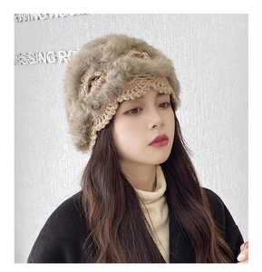 Detail of hand-crocheted warm winter beanie with soft fur trim shown on a model