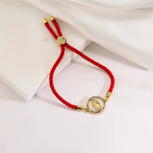 Macro detail of red woven bracelet with colorful zircon Virgin Mary charm and gold slider