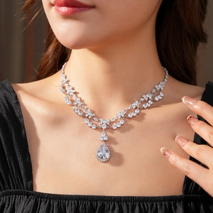 Macro shot of silver zircon flower teardrop pendant necklace with layered chain for women