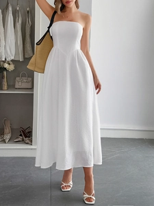Elegant white strapless A-line long dress worn by a model in a modern interior setting