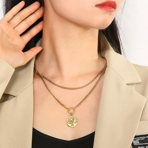 Close-up of golden double-layer Cuban chain necklace with a Tree of Life pendant