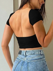 Détail du dos d'un t-shirt noir dos nu coupe ajustée porté avec un jean bleu classique