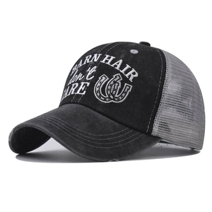 Detail of cross ponytail opening and embroidery on washed denim mesh baseball cap