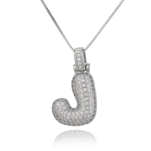 Macro shot of silver letter J pendant with micro-set zircon on fine link chain