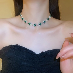 Emerald teardrop necklace with sparkling crystals worn on a model's neck