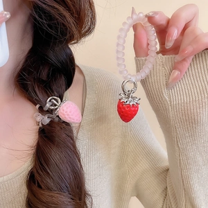 Détail d'un pendentif fraise en peluche sur un élastique spirale avec une grande élasticité