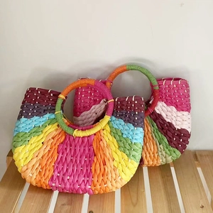 Detailed macro view of vibrant rainbow striped hand-woven moon-shaped straw bags