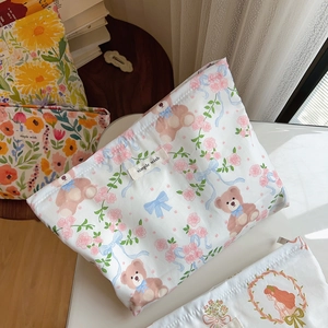 Close-up of cotton cosmetic bag featuring cute bear and rose print with simple wish label