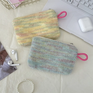 Flat lay of colorful striped plush pouches with items like earbuds and pearls