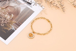 Detail of gold titanium steel chain bracelet with star pendant and sparkling crystals