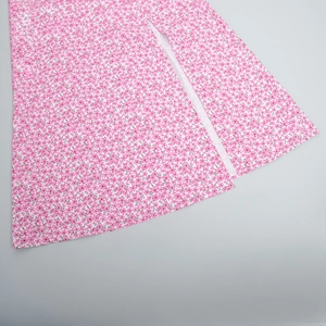 Detailed close-up of side slit on a pink floral dress with soft fabric and neat seams