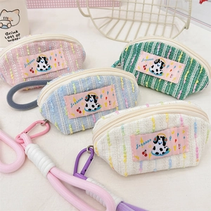 Macro detail of pastel tweed storage pouches with cute dog patches and metal zippers