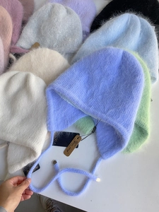 Flache Darstellung verschiedener farbenfroher flauschiger Angora-Ohrklappenmützen für den Winter