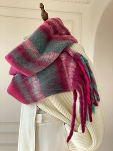 Detail of soft fuzzy check scarf with bold red and green gradient patterns and long tassels