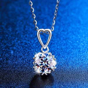 Vista macro di una collana con ciondolo a cuore in argento e una grande pietra taglio brillante