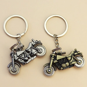 Zinc alloy motorcycle helmet keychain in gunblack and bronze finishes on a light background