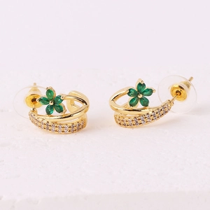 Detail of flower stud earrings with green stones and sparkling pavé crystals