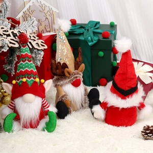 Three festive Christmas gnomes with reindeer antlers and knit hats on snowy background