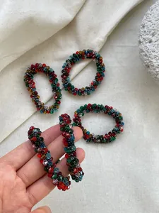 Detail of colorful crystal beaded hair tie with elastic band on textured fabric