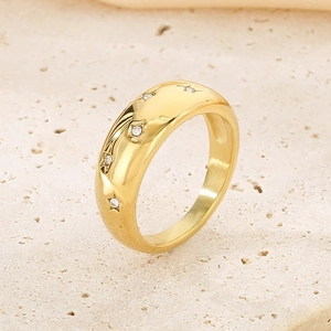 Gros plan d'une bague en acier doré sertie de cinq étoiles en oxydes de zirconium
