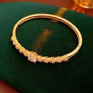 Close-up of gold-plated flower bracelet with sparkling marquise and round zircon stones