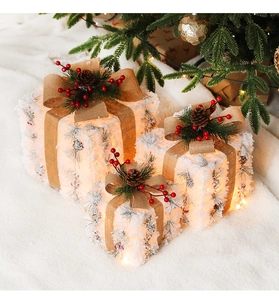 Detail of three-piece Christmas gift boxes with pine cones and warm LED lights