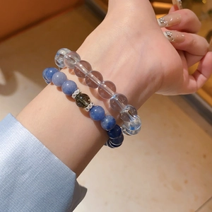 Macro detail of elastic beaded bracelets with blue crystal beads and silver floral spacers