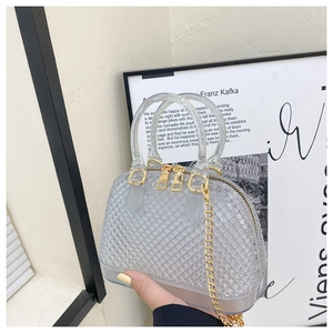 Detail view of gray PVC jelly shell bag with diamond texture and gold metal chain handle