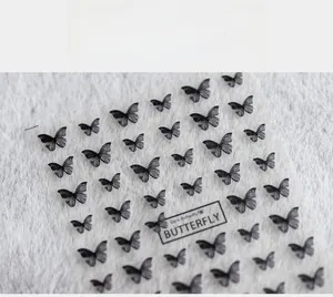 Close-up of 5D dark butterfly nail art stickers with reflective charcoal grey finish