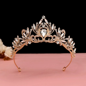 Detailed view of luxury gold crown featuring white crystals and waterdrop gems