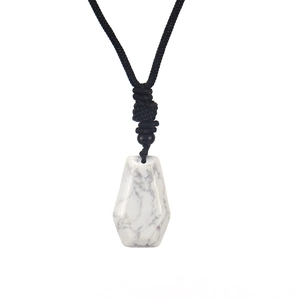 Detail of hexagonal white marble stone pendant with a black hand-woven cord necklace