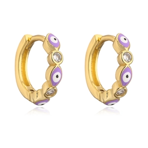 Detail of gold huggie earrings featuring purple evil eye motifs and sparkling cubic zirconia