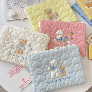 Detailed view of quilted cotton laptop sleeve with cute animal embroidery and metal zipper