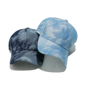Washed denim baseball caps in dark and light blue with acid wash texture on white background