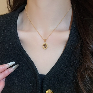 Close-up of a gold-plated vintage flower necklace with sparkling crystal mosaic pendant