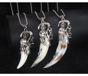Detailed view of grim reaper pendant necklaces with tooth charms in three distinct colors