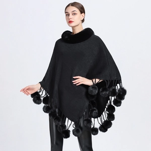 Elegant black knit poncho with faux rabbit fur collar and decorative fur ball tassels