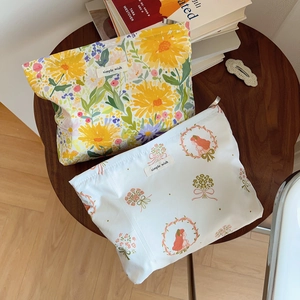 Detail of floral canvas pouches with sunflower and vintage girl prints and zip closure