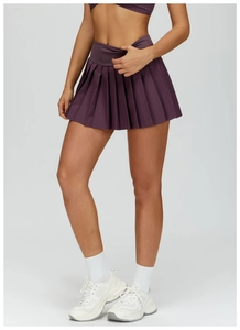 Detail of high-waisted pleated tennis skirt in plum purple with built-in shorts