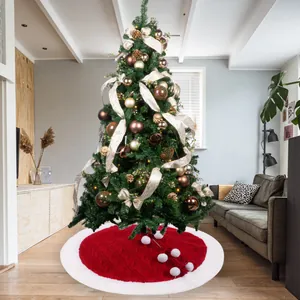 Detail of red cable knit Christmas tree skirt with white plush trim and pom poms