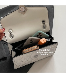 Detail view of double compartments in white snakeskin chain bag showing storage capacity