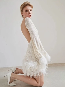 Elegant white sequin mini dress with long sleeves, open back and feather trim details