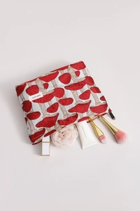Close-up of fabric makeup bag with red mushroom jacquard pattern and metal zipper closure