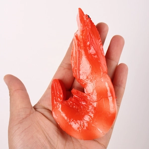 Detailed realistic artificial boiled shrimp model with orange texture shown in hand